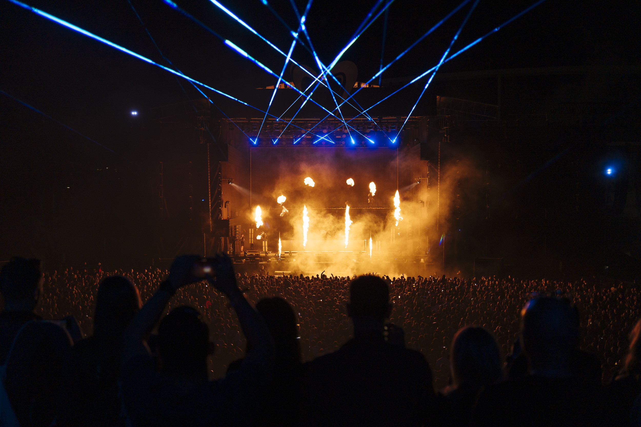 Pyrotechnika i niebieskie lasery nad tłumem — kulminacja sceny