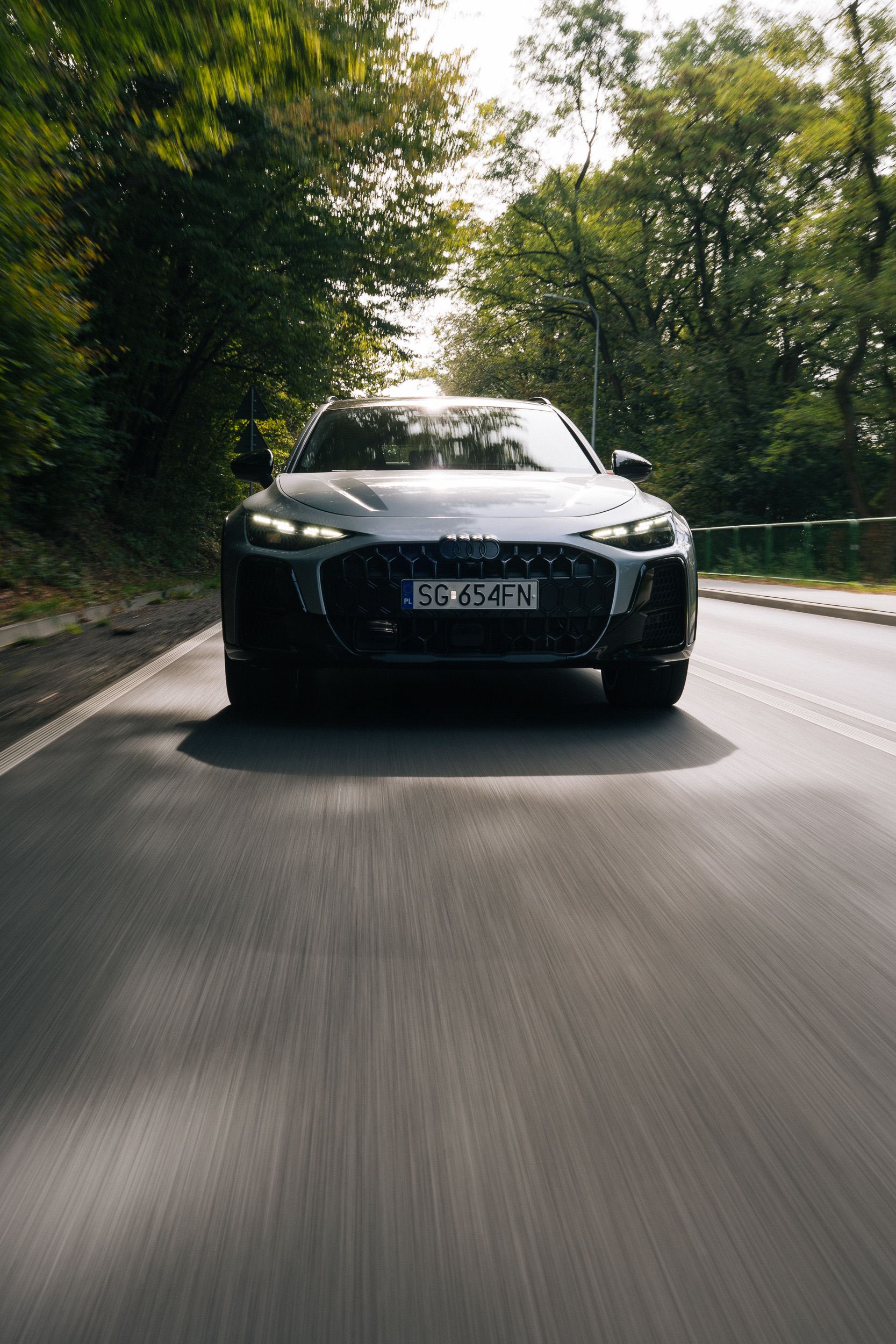 Silberner Audi frontal, darunter verwischter Asphalt — ein Car-to-Car-Bild