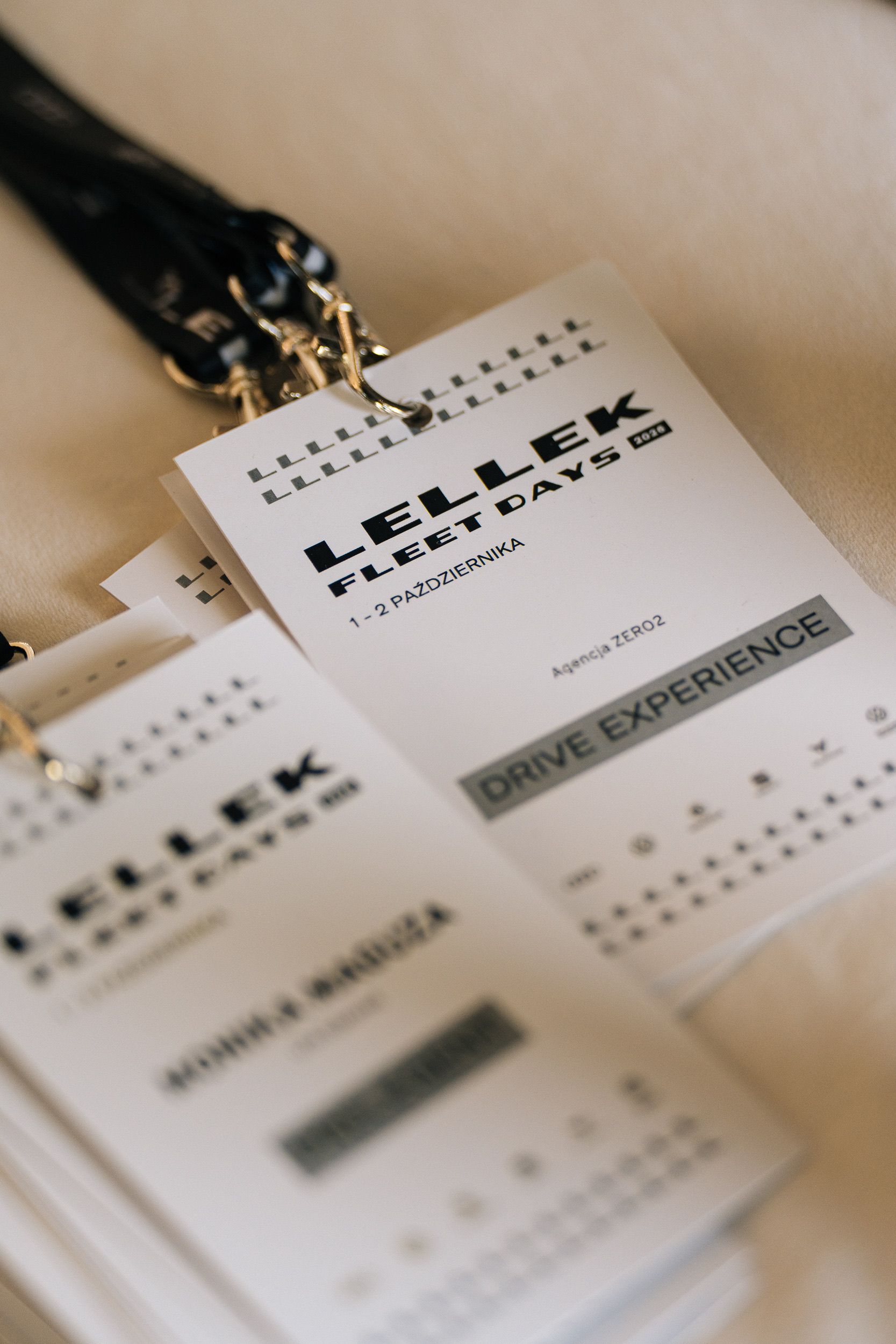 Namensschilder an Bändern mit LELLEK FLEET DAYS 2026 Logo und dem Schriftzug DRIVE EXPERIENCE am Welcome Desk