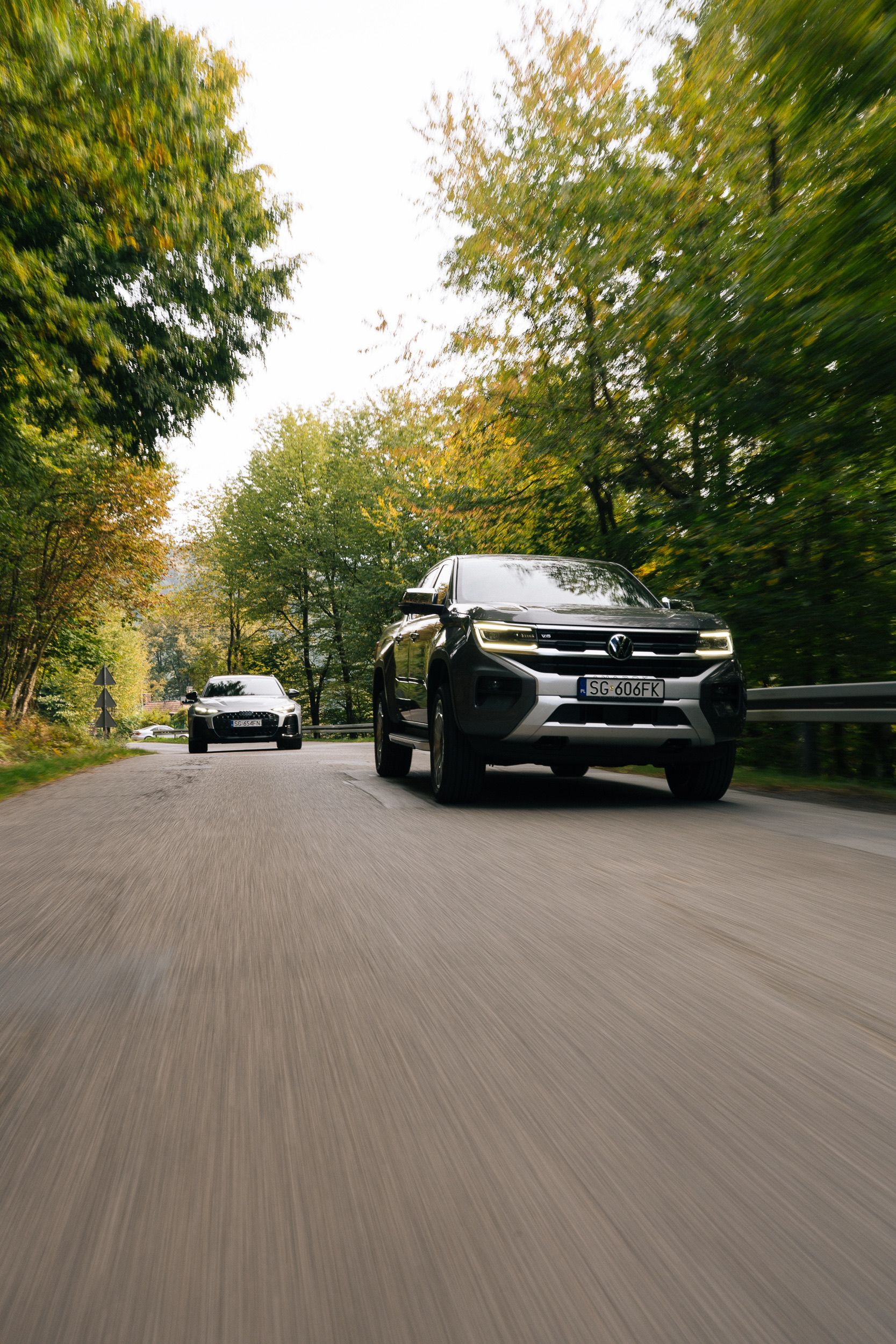 Volkswagen Amarok auf einer Waldstraße, dahinter ein weiteres Auto